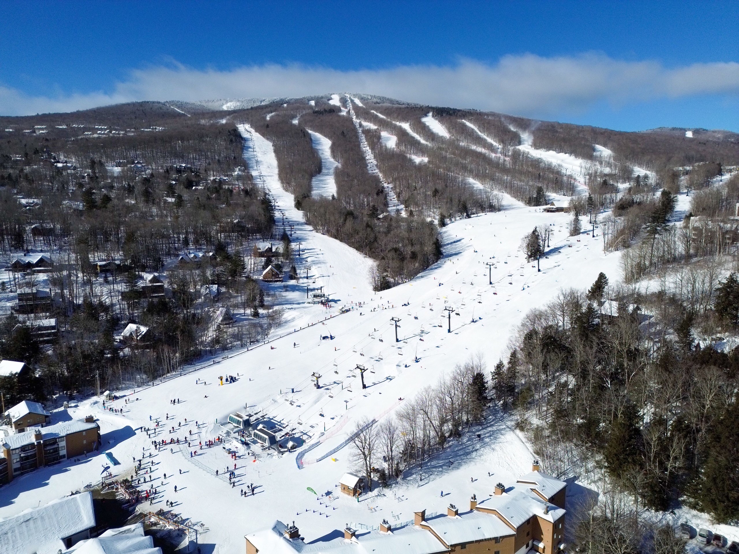 Panoramic winter view of Okemo Mountain with snowy ski trails and blue skies